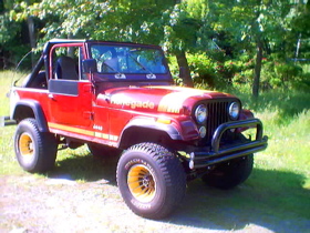 1996 Ford Bronco - A red Jeep CJ-7 Renegade with a yellow stripe and gold wheels is parked outdoors.