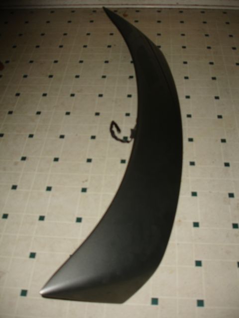 1993 Ford Taurus - A black car spoiler is shown lying on a tiled floor.