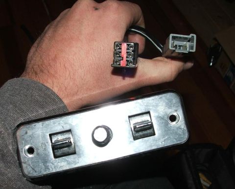 1991 Ford LTD Crown Victoria - A hand holds a car window switch assembly with two rocker switches and associated electrical connectors.