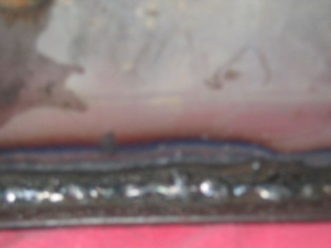 1991 Ford Bronco - A close-up view shows a metallic seam with visible weld marks, against a blurred background.