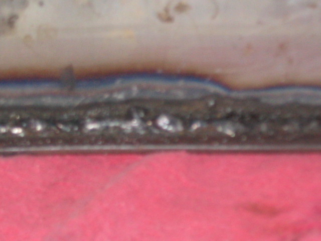 Close-up of a welded metal seam over a pink surface