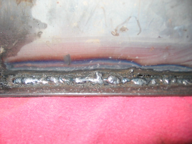 close-up of a rough metal seam with visible weld beads and discoloration