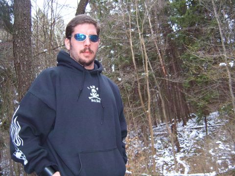 1993 Ford Bronco - A man wearing a black hoodie stands in a snowy forest with bare trees.