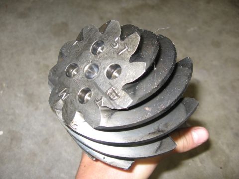1974 Ford F-100 - A hand holds a metal differential gear with visible markings on its surface.
