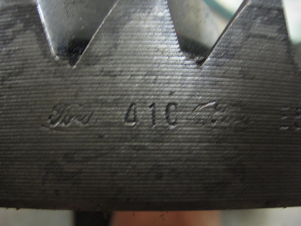 Close-up of a metal gear with "Ford 410" stamped on it