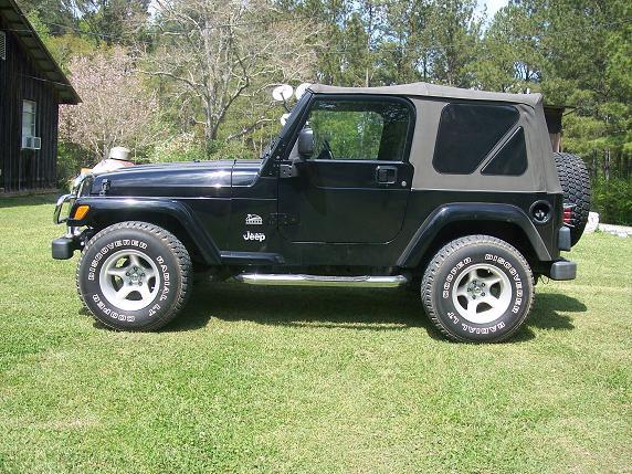 Black Jeep Wrangler side profile on a lawn
