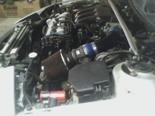 1993 Ford Probe - The engine bay shows an aftermarket air intake system installed on the vehicle.