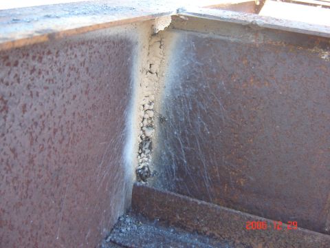 1993 Ford Bronco - Close-up of a rusty, welded metal corner with slag and debris visible.