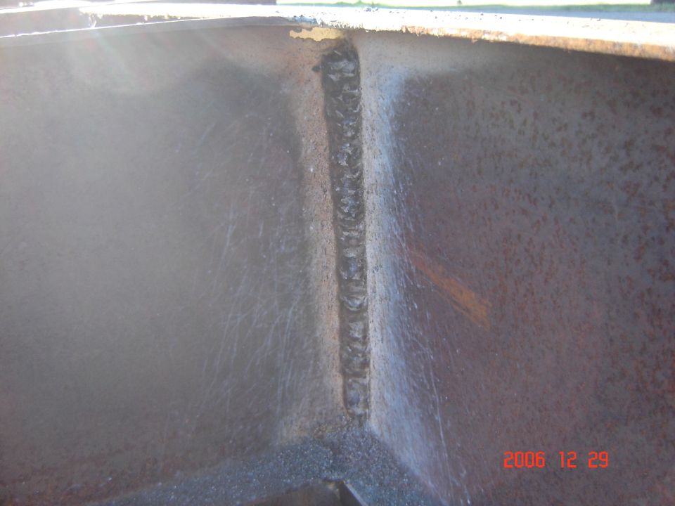 Welded metal seam inside a dark, possibly rusted, container