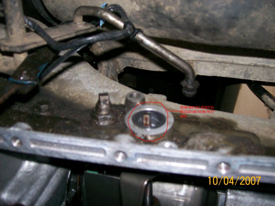 Close-up of a vehicle's transmission with a red circle around a part labeled 'BRAND NEW THROTTLE BUSHING INSTALLED AND FEELING PRETTY'