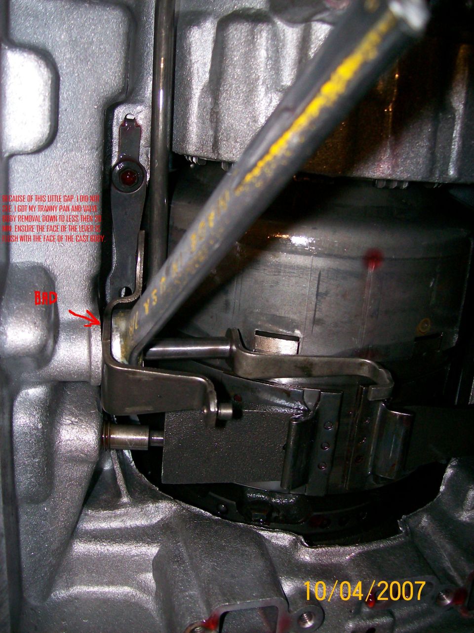Close-up of transmission linkage with handwritten notes on the casing