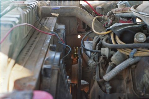 1978 Ford Bronco - A close-up view of an engine bay, focusing on the radiator, belts, and various hoses.