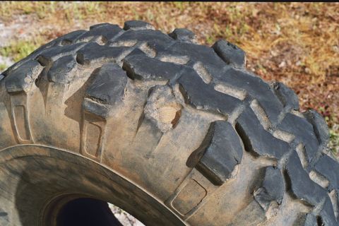 1978 Ford Bronco - Close-up of a worn mud-terrain tire with a prominent tread pattern.
