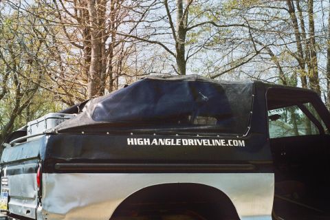 1978 Ford Bronco - Side view of a 1978 Ford Bronco a black soft top with a website address printed on it.