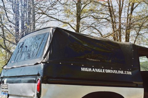 1978 Ford Bronco - The rear of a 1978 Ford Bronco features a black soft top with visible text and a license plate.
