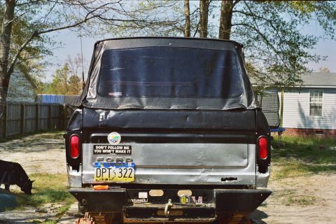 1978 Ford Bronco - The rear of a 1978 Ford Bronco shows a soft top, a "Don't Follow Me" sticker, and a license plate.