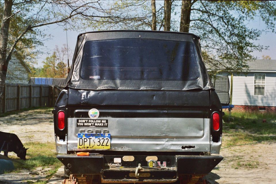 1978 Ford Bronco rear view with soft top, black and silver paint, and a "Don't Follow Me" sticker