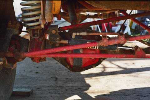 1978 Ford Bronco - Close-up view of the undercarriage, focusing on the red-painted suspension and differential system.