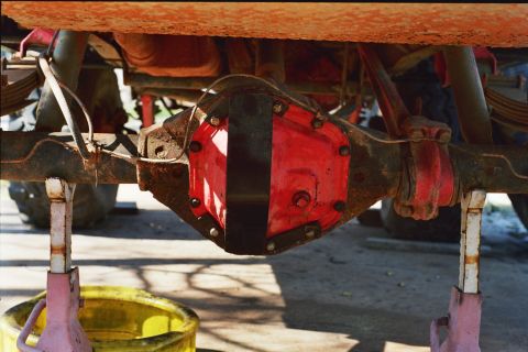 1978 Ford Bronco - Close-up view of a vehicle's rear axle differential, painted red and black, resting on jack stands.