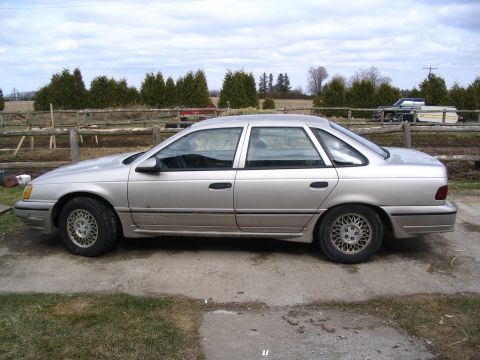 1993 Ford Taurus - Side profile of a silver 1989 Ford Taurus sedan with a rural background.