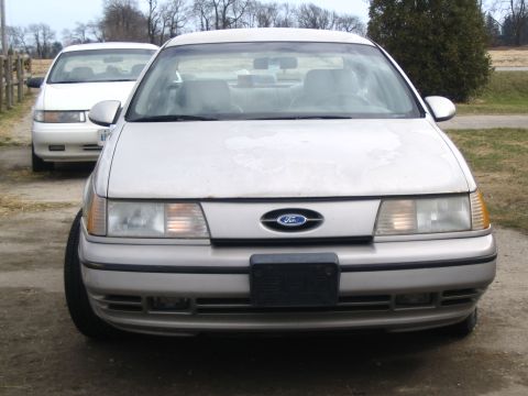 1993 Ford Taurus - A 1993 Ford Taurus is seen from the front, with another car parked behind it.