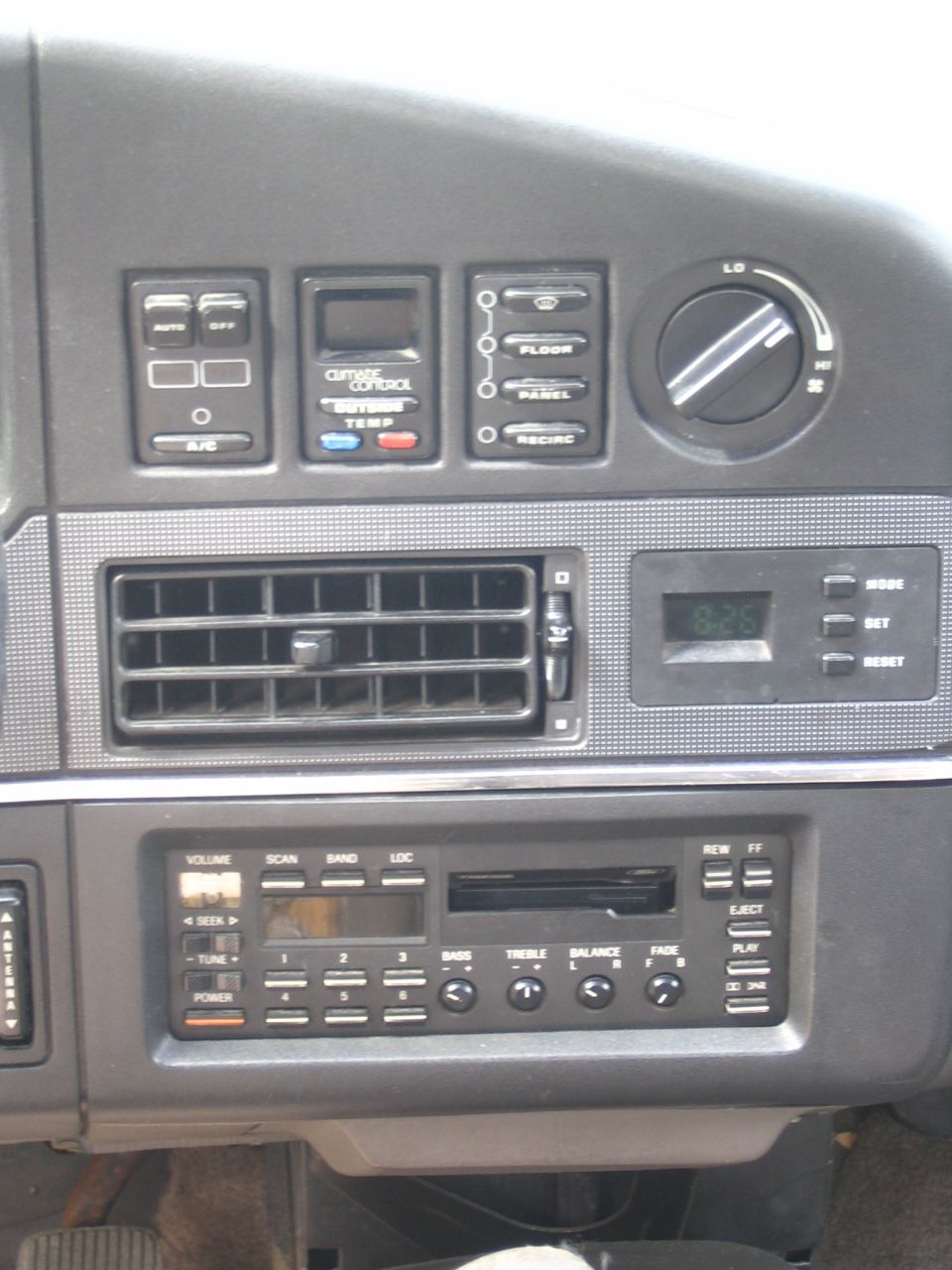 car dashboard with climate controls, air vents, and radio