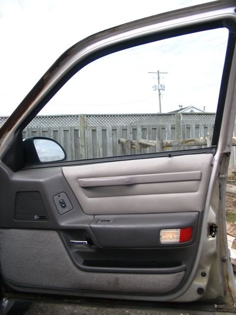 1993 Ford Taurus - View of the interior door panel and window mechanism from inside a vehicle.