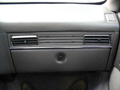 1993 Ford Taurus - Close-up of a car's dashboard showing the air vents and glove compartment latch.