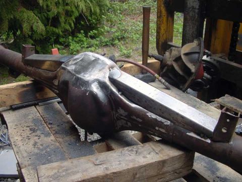 1979 Ford Bronco - A modified rear axle housing is shown, supported by wooden planks outdoors.