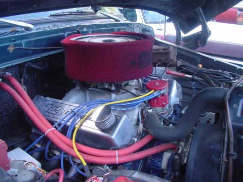 1979 Ford Bronco - Engine bay view of a Ford V8, with a red air filter and blue spark plug wires.