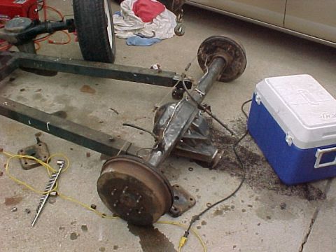 1978 Ford Bronco - A rear axle assembly, likely from a truck or SUV, is shown with its drum brakes and suspension parts.
