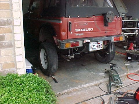 1978 Ford Bronco - Rear view of a red Suzuki Samurai with a Texas license plate.