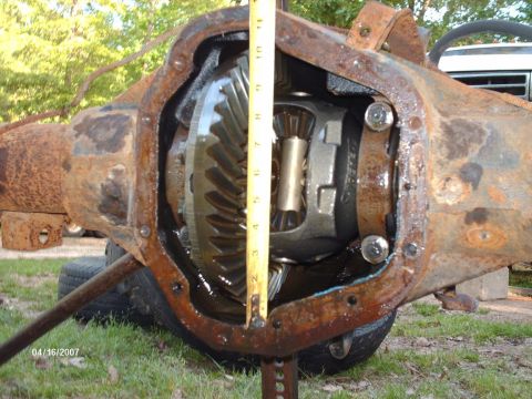 1990 Ford F-150 - A tape measure is used to gauge the size of the internal gears within a rusty differential housing.