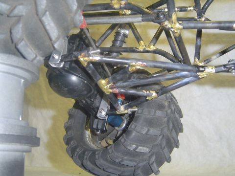 1993 Ford Bronco - Close-up view of the suspension system and tire of a custom off-road vehicle.