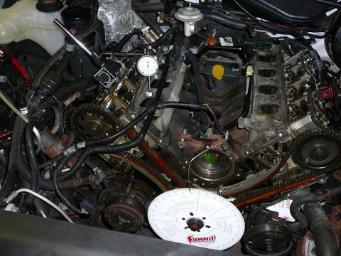 1997 Mercury Grand Marquis - Close-up of an engine during a timing setup procedure, showing mechanical components and tools.