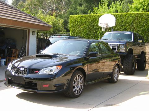 2007 Subaru Impreza - A black 2007 Subaru Impreza WRX STI is parked in front of a lifted Ford Bronco.