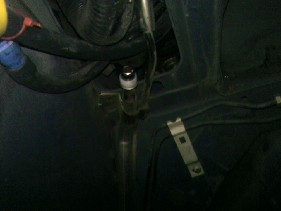 Close-up view of some hoses and metal brackets under a car