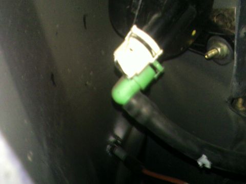1978 Ford Mustang II - A close-up view of a green and black hose connector with a white clip, likely a part from a vehicle.