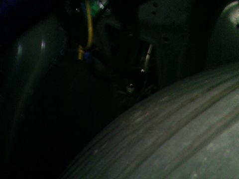 1978 Ford Mustang II - A dark shot of a vehicle's wheel well, showing some wiring and the tire tread.