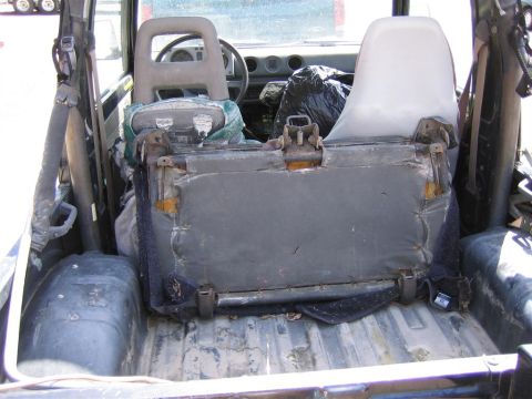 1987 Suzuki Samurai - The interior of a Suzuki Samurai shows its rear bench seat and the cargo area behind it.