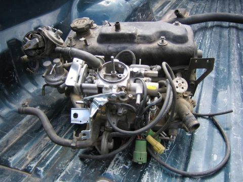 1987 Suzuki Samurai - This engine assembly is shown in a truck bed, with various hoses and electrical connectors visible.