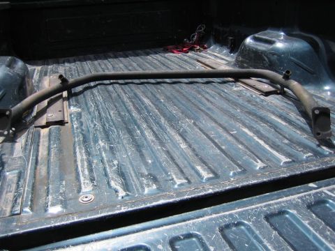 1987 Suzuki Samurai - A metal roll bar is positioned in the bed of a pickup truck.