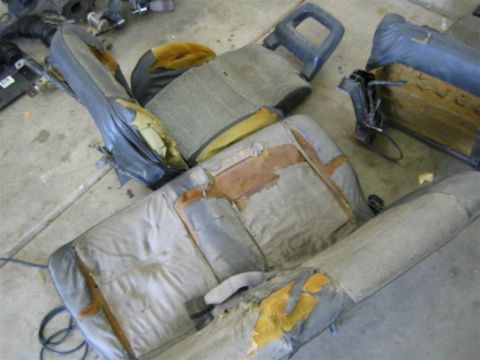 1987 Suzuki Samurai - Interior car seats are shown in a state of disrepair, with torn upholstery revealing foam padding.