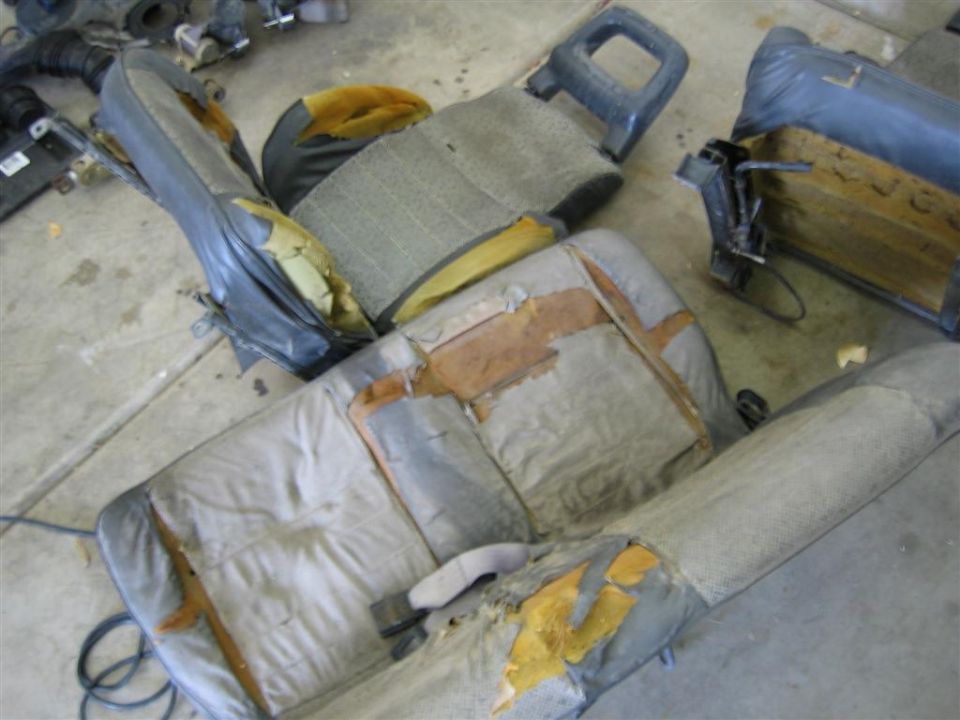 Worn interior car seats, some torn and showing foam