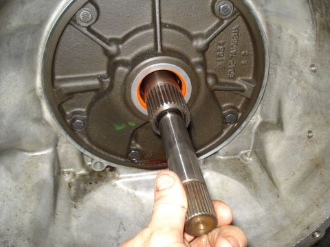1984 Ford Bronco - Close-up of a transmission pump shaft being inserted into its housing, with part numbers visible on the housing.