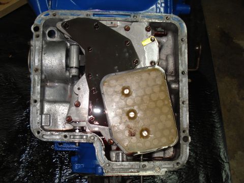 1984 Ford Bronco - The transmission pan is removed, revealing the filter and internal workings of the automatic transmission.