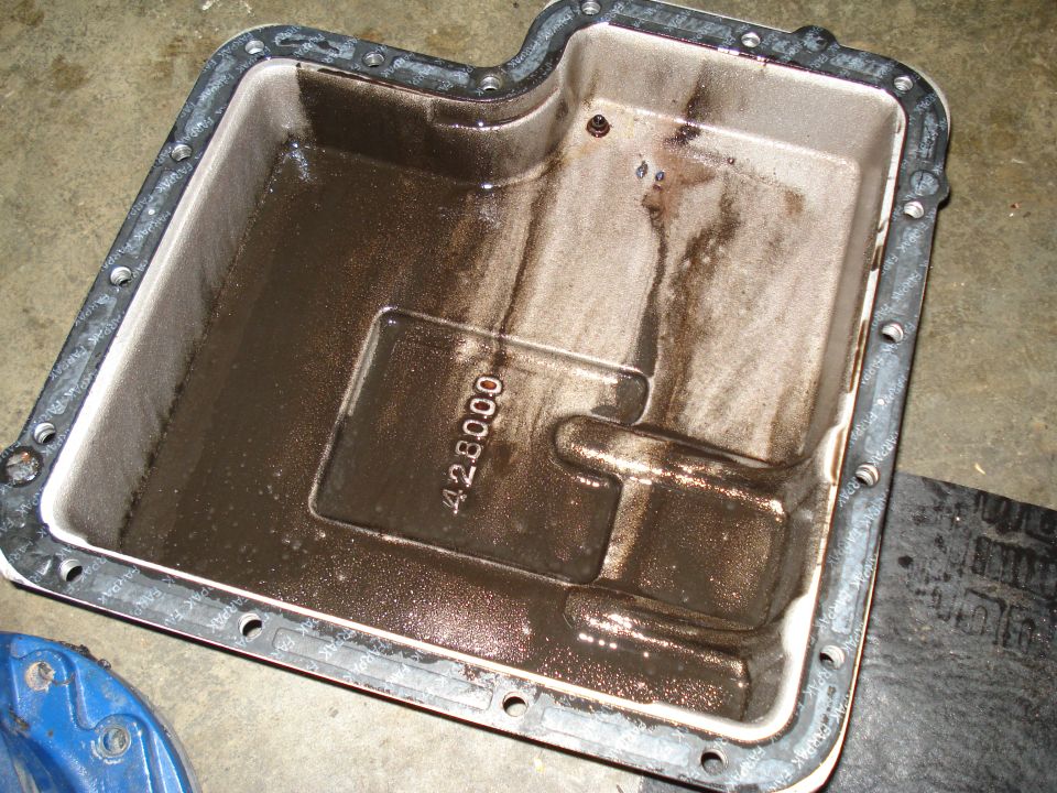 Transmission oil pan with sludge and a visible part number '428000'
