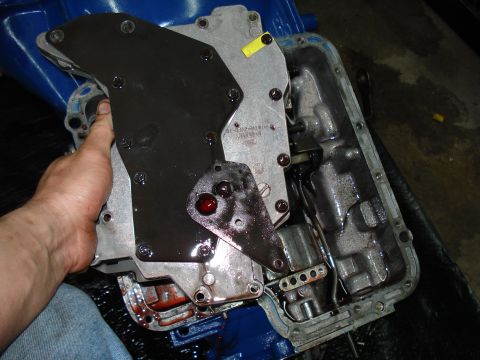 1984 Ford Bronco - Automatic transmission valve body being held, showing internal components and fluid.