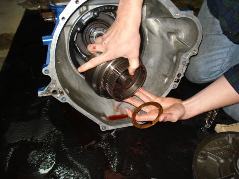 1984 Ford Bronco - Mechanic's hands work on transmission components, removing a torque converter.