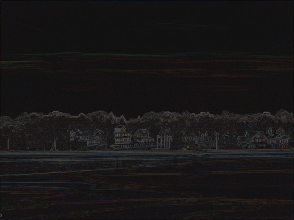 Waterfront houses and trees under a dark sky